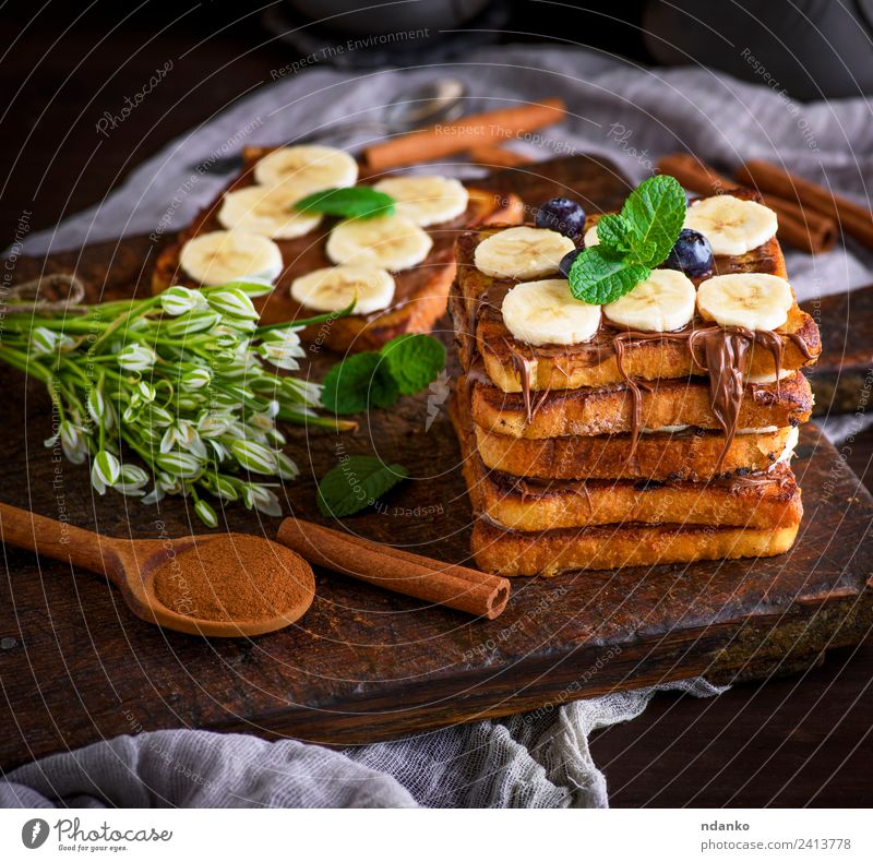 Französischer Toast auf das Frühstück Frucht Brot Dessert Ernährung Löffel Blume Holz frisch lecker oben Tradition Zuprosten Banane Schokolade Hintergrund