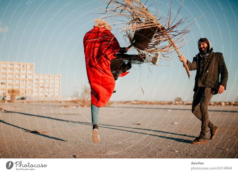 Coole Frauen und Männer, die draußen bei Sonnenuntergang mit Pflanzen und Zweigen spielen und Kämpfe austragen. Lifestyle Freude Freizeit & Hobby Spielen Mensch