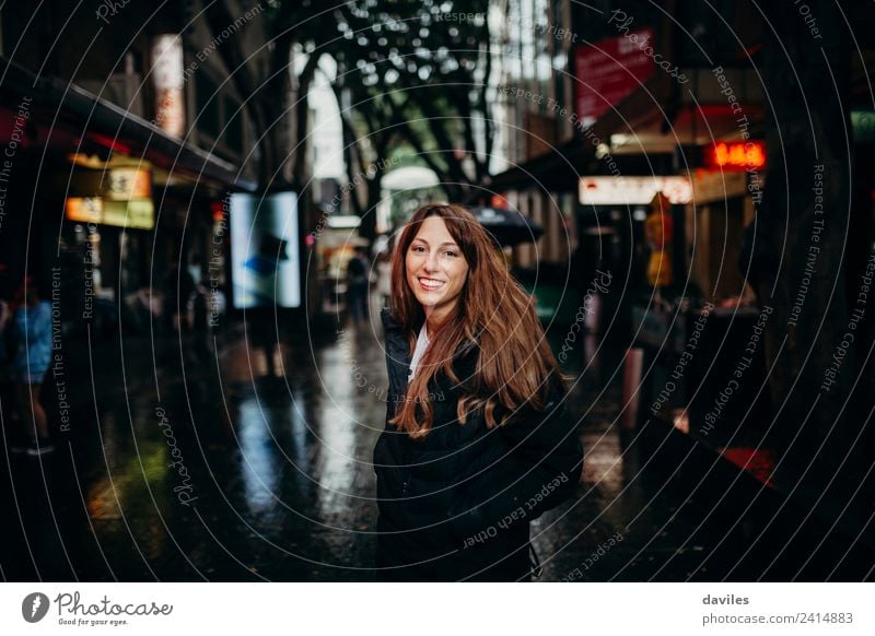 Blondes, hübsches Mädchen schaut in die Kamera, während es durch das Viertel Chinatown in der Stadt Sydney, Australien, spaziert. kaufen