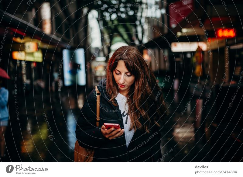 Junge Frau auf der Suche nach einem Restaurant in ihrem Mobiltelefon in der Stadt Sydney. kaufen Ferien & Urlaub & Reisen Tourismus Business Telefon Funktelefon