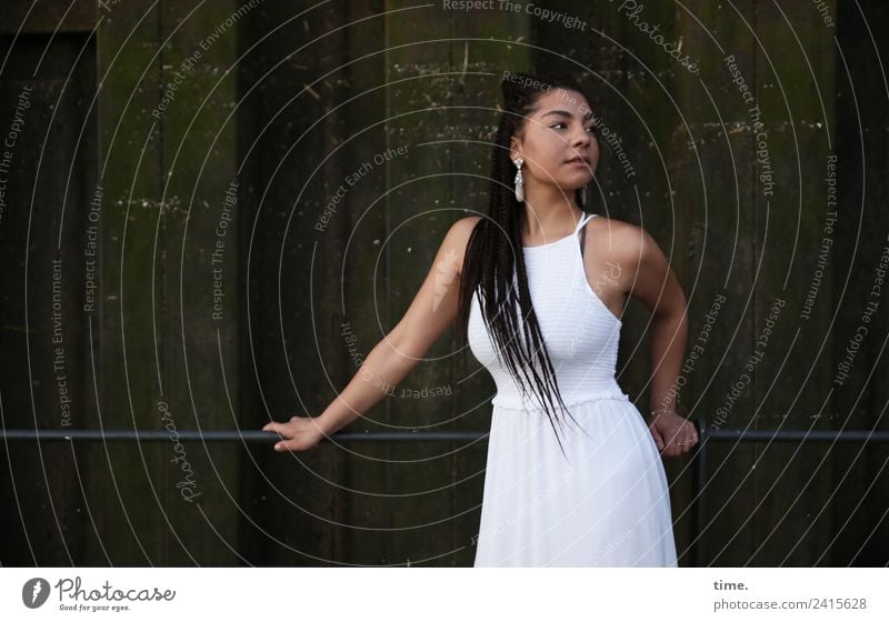 Nikolija feminin Frau Erwachsene 1 Mensch Mauer Wand Kleid Ohrringe schwarzhaarig langhaarig Zopf beobachten festhalten Blick stehen dunkel schön Zufriedenheit