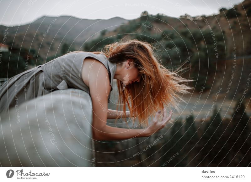 Frau lehnt sich an eine Brücke, während der Wind ihr Haar bewegt. Lifestyle schön Ferien & Urlaub & Reisen Tourismus Mensch Erwachsene 1 18-30 Jahre Jugendliche