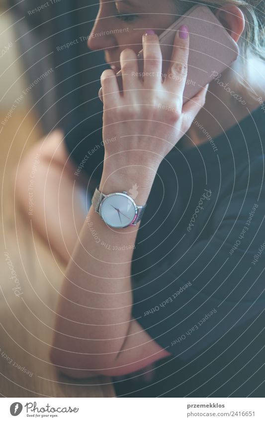 Frau, die am Telefon anruft und blaues Kleid und silberne Armbanduhr trägt. Lifestyle elegant Stil Uhr Business sprechen Handy Technik & Technologie Mensch