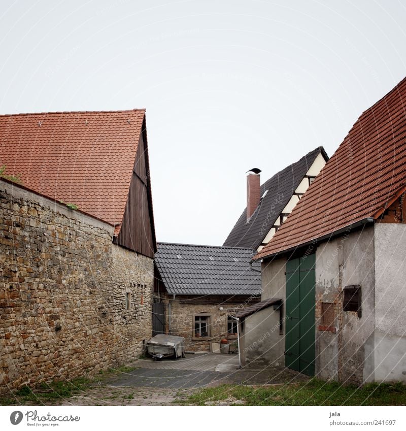 aussiedlerhof Himmel Gras Dorf Haus Platz Bauwerk Gebäude Architektur Mauer Wand Fassade Fenster Dach Schornstein trist Farbfoto Außenaufnahme Menschenleer