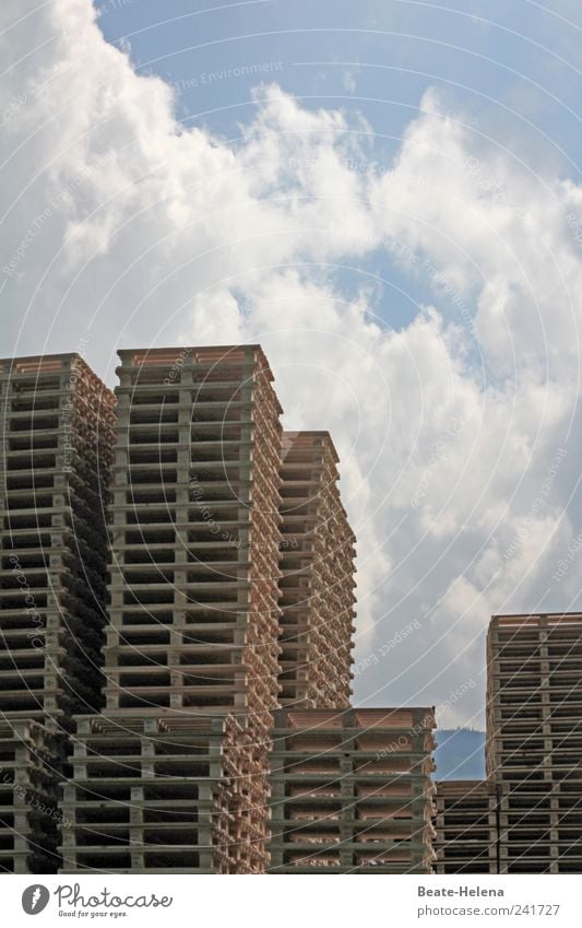 Im Zentrum der Hochstapler Hausbau Arbeitsplatz Paletten Personenverkehr Wirtschaft Handel Himmel Wolken Schönes Wetter Hochhaus Holz eckig hell hoch blau braun