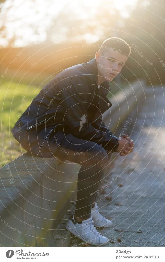 Junger Mann sitzt im Freien Stil Mensch maskulin Jugendliche Erwachsene 1 13-18 Jahre Mode Bekleidung Jeanshose Jacke Leder Holz sitzen authentisch Coolness