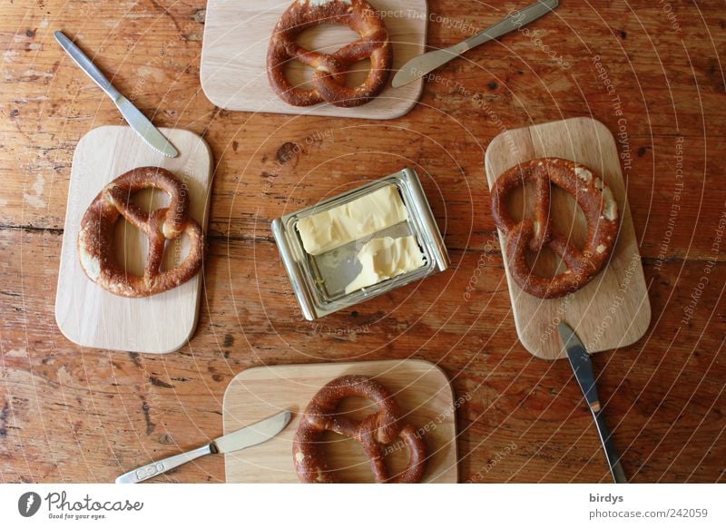 Laugenbrezeln mit Butter für 4 Personen Brezel Backwaren Schneidebrett Brezeln Frühstück Messer butterdose Lebensmittel Holztisch Vogelperspektive genießen