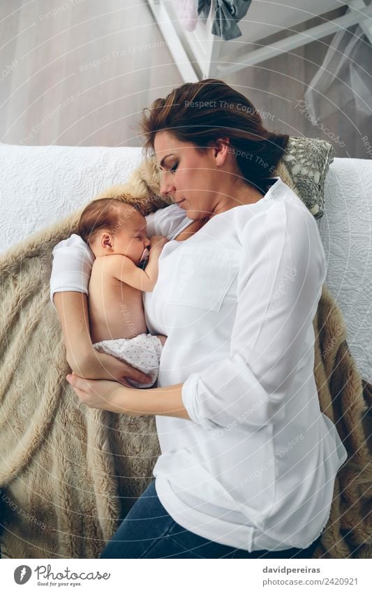 Mutter umarmt ihr neugeborenes Mädchen. Lifestyle elegant schön Schlafzimmer Kind Mensch Baby Frau Erwachsene Familie & Verwandtschaft Fluggerät Liebe Umarmen