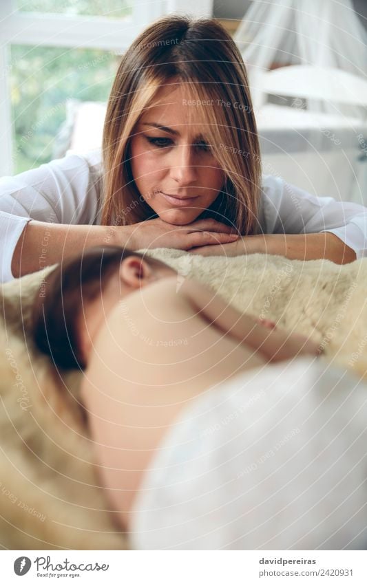 Baby schläft auf einer Decke, während ihre Mutter schaut. schön ruhig Schlafzimmer Kind Mensch Frau Erwachsene beobachten Liebe schlafen authentisch klein