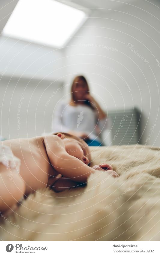 Baby schläft auf einer Decke, während ihre Mutter schaut. schön ruhig Schlafzimmer Kind Mensch Frau Erwachsene beobachten Liebe schlafen authentisch klein