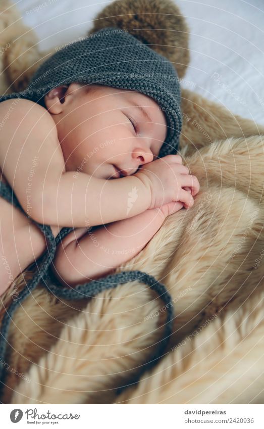 Neugeborenes Baby mit Pomponmütze schlafend auf Decke schön Windstille Schlafzimmer Kind Mensch Frau Erwachsene Wärme Hut authentisch klein nackt niedlich