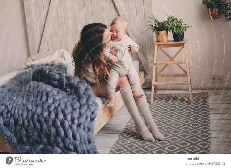 glückliche Mutter und Baby, die zu Hause im Schlafzimmer spielen. Lifestyle Freude Spielen Eltern Erwachsene Familie & Verwandtschaft Küssen Liebe Umarmen