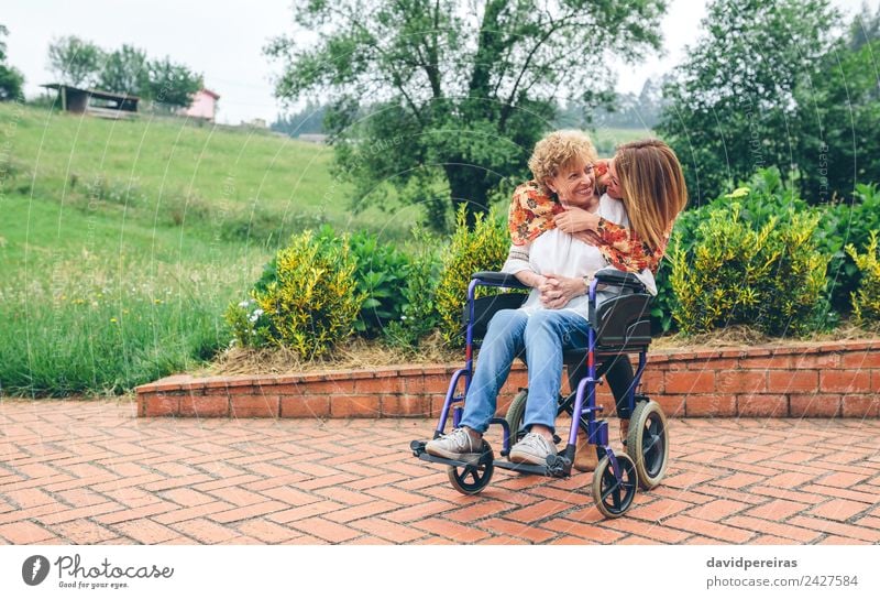 Tochter umarmt ältere Mutter im Rollstuhl Lifestyle Glück Gesundheitswesen Erholung Garten Mensch Frau Erwachsene Großmutter Familie & Verwandtschaft Natur