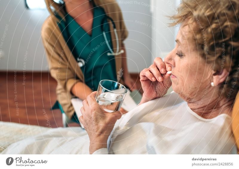 Älterer Patient, der neben dem Arzt die Pille nimmt Gesundheitswesen Behandlung Krankheit Medikament Haus Krankenhaus Mensch Frau Erwachsene alt authentisch