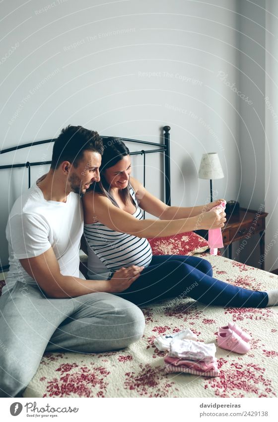 Mann und schwangere Frau suchen Babykleidung kaufen schön Schlafzimmer Mensch Erwachsene Mutter Vater Familie & Verwandtschaft Paar Partner Bekleidung Hemd