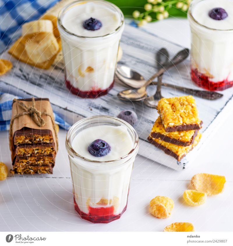 Joghurt im Klarglas Milcherzeugnisse Marmelade Ernährung Frühstück Diät Getränk Erfrischungsgetränk Löffel Tisch Blume Holz natürlich oben blau weiß Tradition