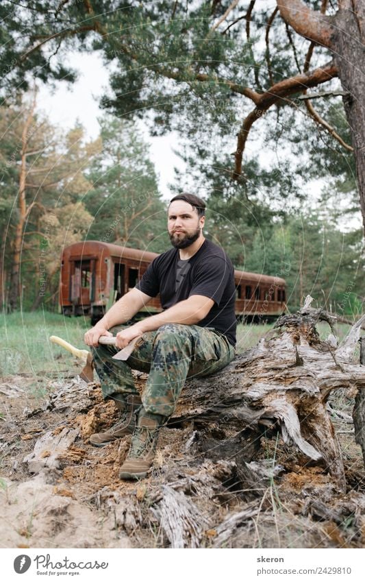 bärtiger Jäger, der auf der Wurzel eines trockenen Baumes sitzt. Lifestyle Freizeit & Hobby Ferien & Urlaub & Reisen Tourismus Abenteuer Mensch maskulin Mann