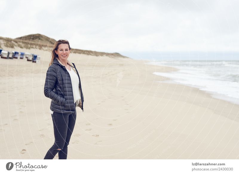 Frau, die an einem bewölkten Tag am Strand spazieren geht. Freizeit & Hobby Freiheit Meer Erwachsene 1 Mensch 45-60 Jahre Sand Wolken Herbst Küste Nordsee