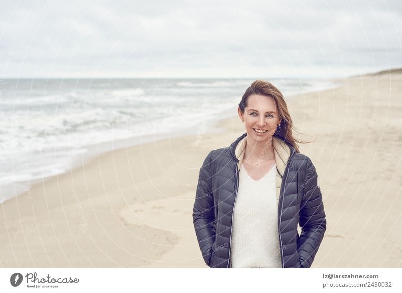 Frau, die an einem bewölkten Tag am Strand spazieren geht. Freizeit & Hobby Freiheit Meer Erwachsene 1 Mensch 45-60 Jahre Sand Wolken Herbst Küste Nordsee