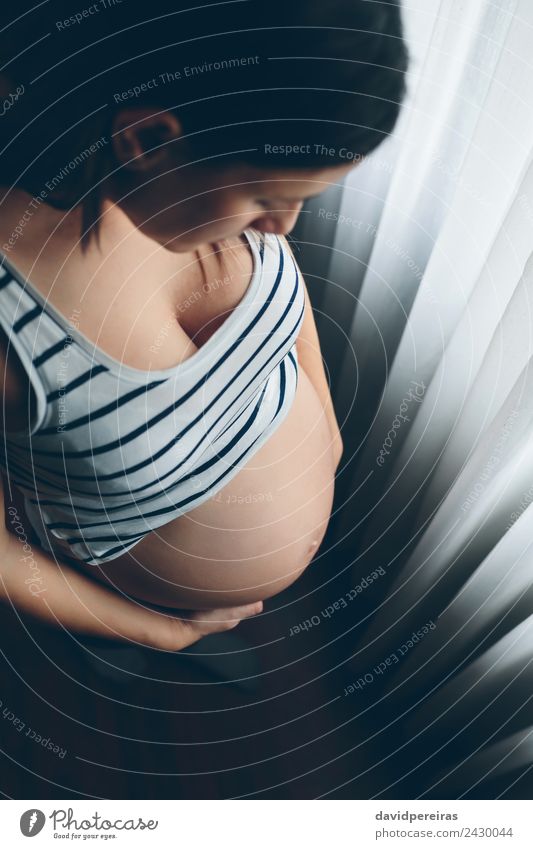 Schwangere Frau, die ihren Bauch ansieht. Lifestyle schön Leben Kindererziehung Mensch Baby Erwachsene Mutter Hand Denken Liebe warten authentisch nackt