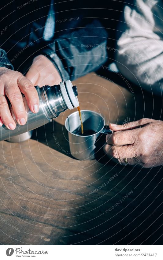 Senior Paar Hände gießen Kaffee aus der Thermoskanne. trinken Tee Lifestyle Erholung Freizeit & Hobby Tisch Mensch Frau Erwachsene Mann Hand Holz Metall alt