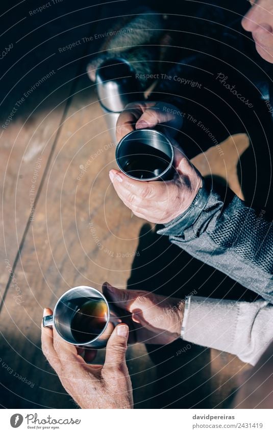 Senior Paar Hände halten Tassen mit Kaffee. trinken Tee Lifestyle Erholung Freizeit & Hobby Tisch Mensch Frau Erwachsene Mann Hand Holz Metall Liebe sitzen