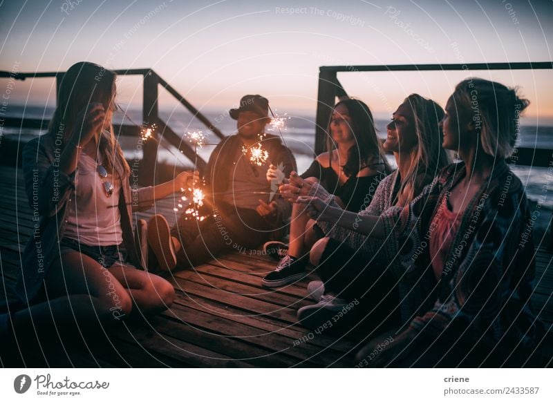 Freunde genießen den Sonnenuntergang mit Funkeln auf einem Pier. Freude Glück schön Freiheit Sommer Meer Mann Erwachsene Freundschaft Menschengruppe Natur