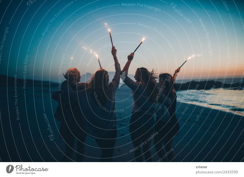 Glückliche Gruppe von Freundinnen, die am Strand mit Wunderkerzen feiern. Lifestyle Freude schön Leben Sommer Sonne Meer Frau Erwachsene Freundschaft Natur Sand