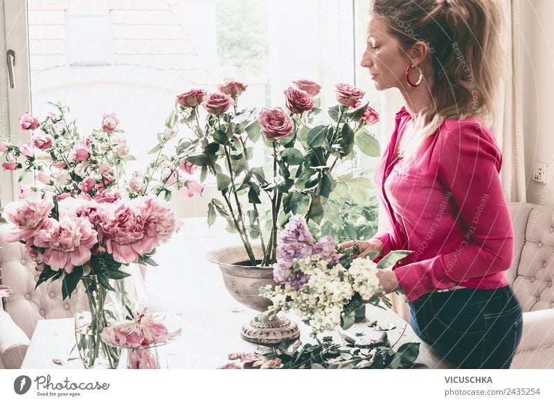 Frau arrangiert Blumestrauß mit Rosen in Vase Lifestyle Reichtum Stil Design Freizeit & Hobby Wohnung Innenarchitektur Dekoration & Verzierung Wohnzimmer Party