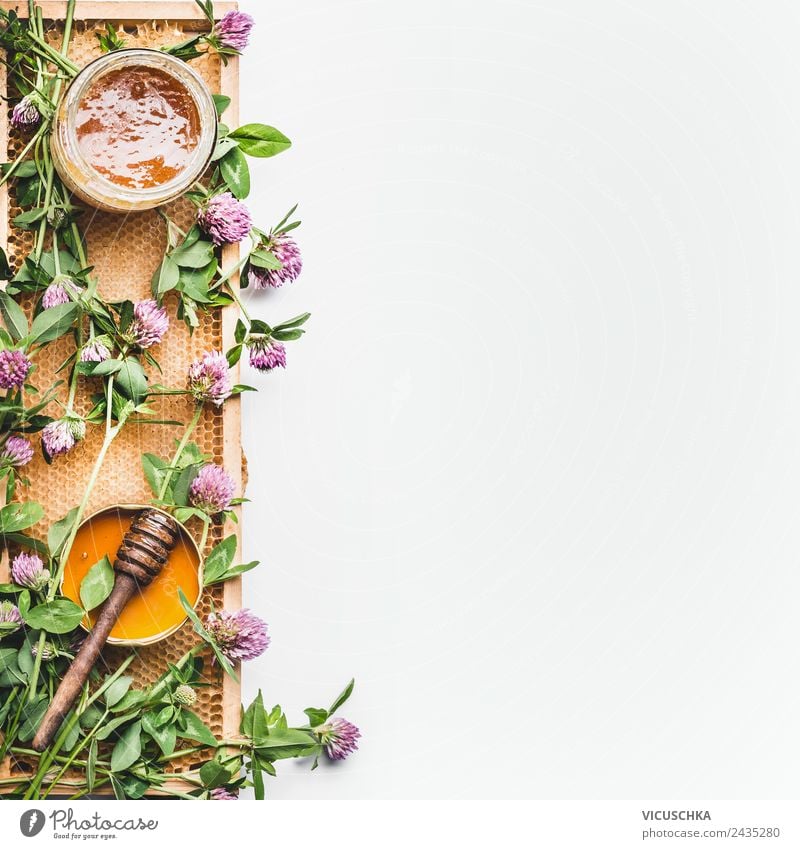 Honig im Glas mit Schöpflöffel, Bienenwaben und wilden Blumen Leben gelb honey jar dipper honeycomb frame white Hintergrundbild Top view healthy food flat lay