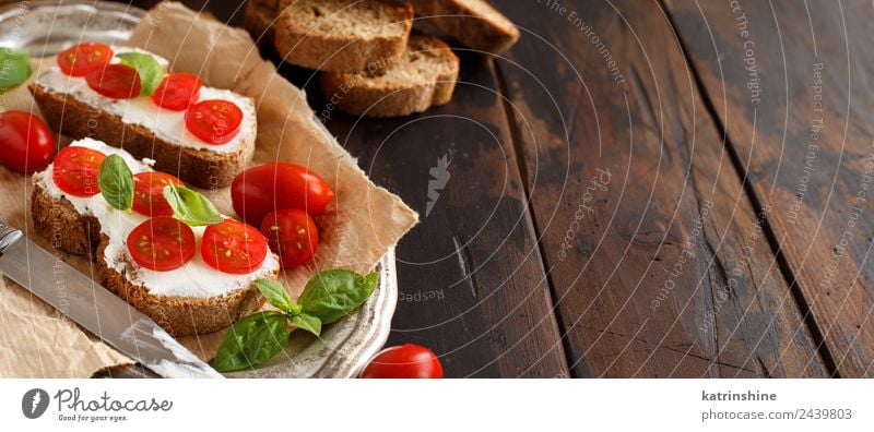 Bruschetta mit Frischkäse, Kirschtomaten und Basilikum Käse Brot Essen Frühstück Mittagessen frisch grün Amuse-Gueule Baguette Holzplatte Essen zubereiten Sahne