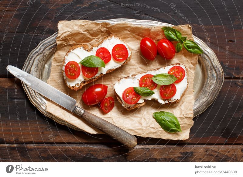 Bruschetta mit Frischkäse, Kirschtomaten und Basilikum Käse Brot Essen Frühstück Mittagessen frisch grün Amuse-Gueule Baguette Holzplatte Essen zubereiten Sahne