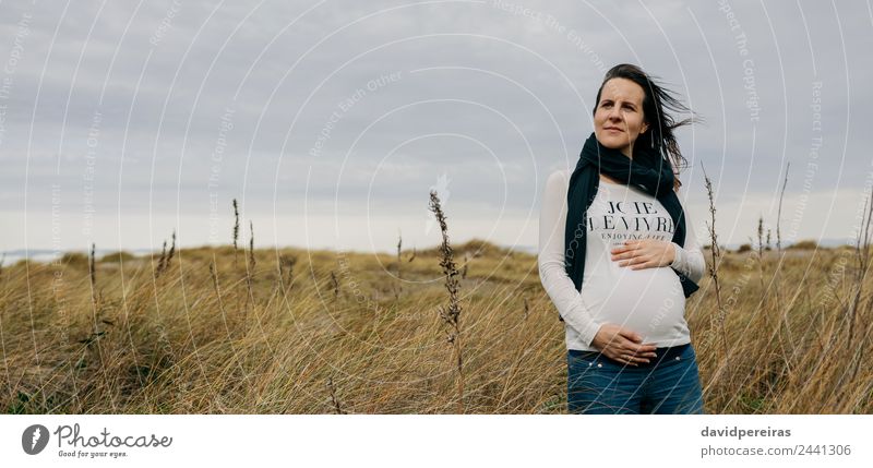 Schwangere Frau, die ihren Bauch streichelt. Lifestyle Freude Glück Mensch Baby Erwachsene Mutter Hand Natur Landschaft Gras Wiese Schal berühren Lächeln warten