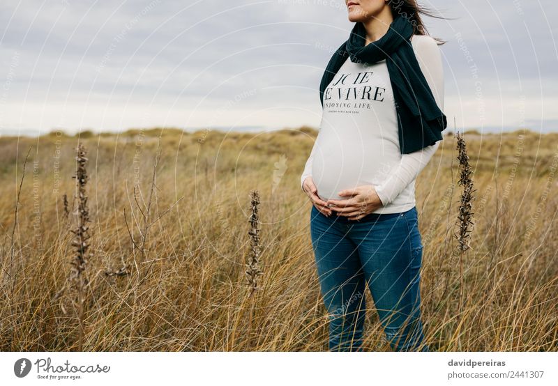 Frau streichelt ihren Bauch im Feld Lifestyle Freude Glück Leben Mensch Baby Erwachsene Mutter Hand Natur Landschaft Gras Wiese Schal berühren Lächeln warten