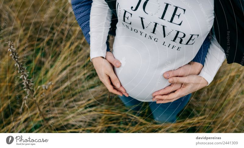 Schwangerschaft mit Partnerumarmung und Bauchhaltung Lifestyle schön Mensch Frau Erwachsene Mann Mutter Paar Hand Natur Landschaft Gras Wiese Fluggerät berühren