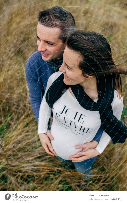 Schwangerschaft mit Partnerumarmung und Bauchhaltung Lifestyle Glück schön Mensch Frau Erwachsene Mann Mutter Paar Natur Landschaft Wind Gras Wiese Fluggerät