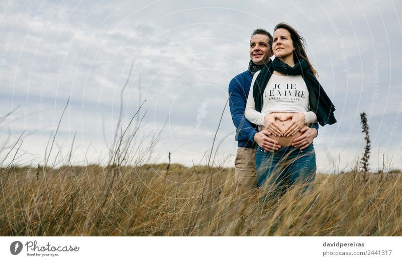 Schwanger machendes Herz mit Händen auf nacktem Bauch mit Partnerin Lifestyle Glück Mensch Frau Erwachsene Mann Mutter Paar Hand Natur Landschaft Horizont Wiese