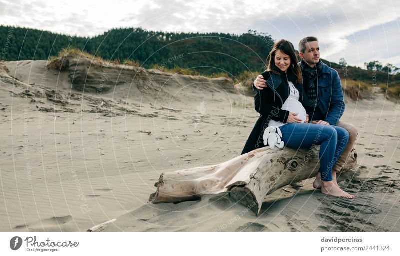 Schwanger am Strand mit ihrer Partnerin Lifestyle Glück Winter Mensch Frau Erwachsene Mann Mutter Vater Paar Fuß Sand Herbst Mantel Teddybär Lächeln Liebe