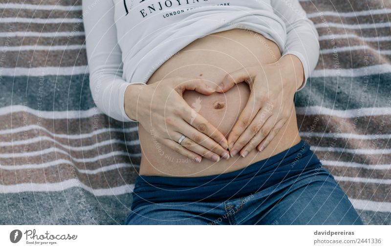 Schwangerer Bauch auf einer Decke liegend Lifestyle Leben Erholung Mensch Baby Frau Erwachsene Eltern Mutter Hand Fluggerät Ring berühren authentisch nackt