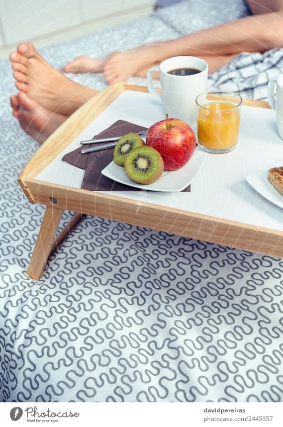 Gesundes Frühstück auf Tablett und Paar Beine im Hintergrund Frucht Apfel Saft Kaffee Lifestyle Glück Erholung Freizeit & Hobby Schlafzimmer Frau Erwachsene