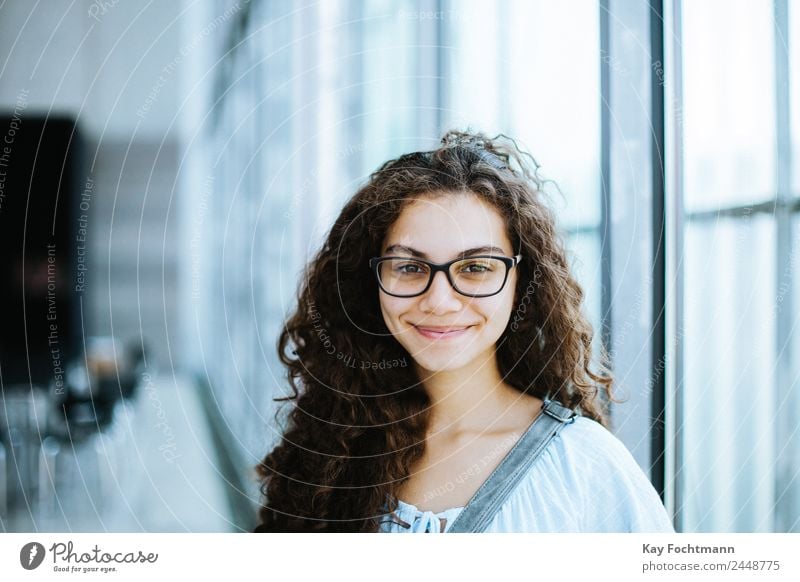 niedliches brasilianisches Mädchen mit lockigem Haar und legerer Kleidung lächelt für die Kamera attraktiv schön Brasilianer lässig clever Ethnizität verlassen