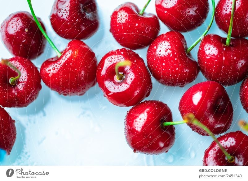 frische Kirschen mit Wassertropfen, die auf einem hellen Untergrund liegen Lebensmittel Frucht Ernährung Bioprodukte Vegetarische Ernährung Diät Gesundheit