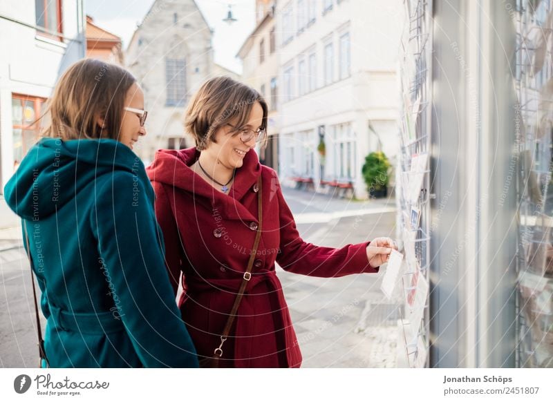 Zwillinge schauen sich Postkarten an Lifestyle Freude Glück Mensch feminin Junge Frau Jugendliche Geschwister Schwester 2 Lebensfreude Außenaufnahme Ausflug