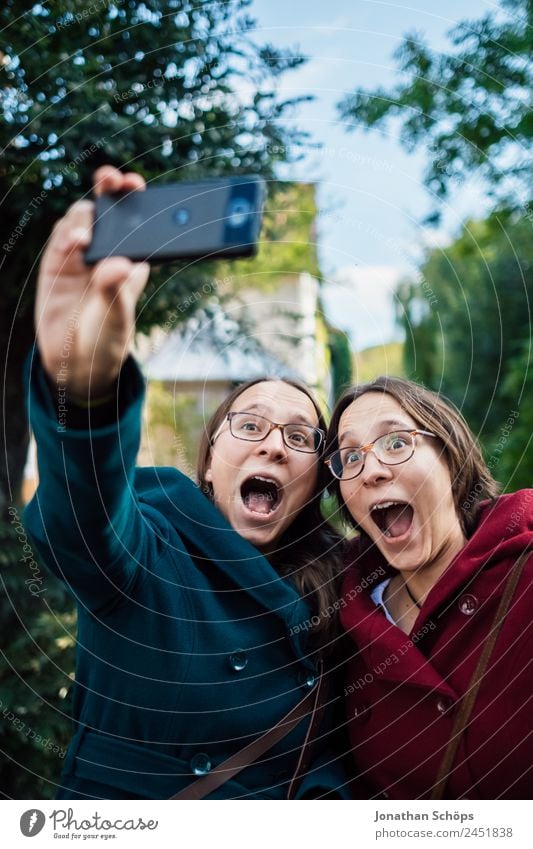 lustige Zwillingsschwestern machen ein Selfie mit dem Smartphone Lifestyle Freude Glück Mensch feminin Junge Frau Jugendliche Geschwister Schwester Leben 2