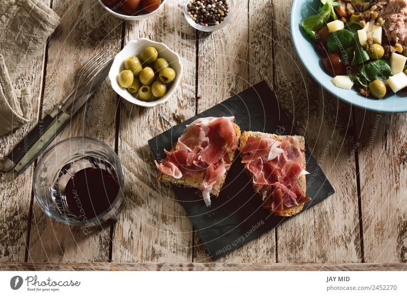 Köstliche Vorspeise mit spanischem Schinken und Salat Spanisch Brot Toastbrot Amuse-Gueule Kochen geschnitten Belegtes Brot iberisch Schweinefleisch Mittagessen