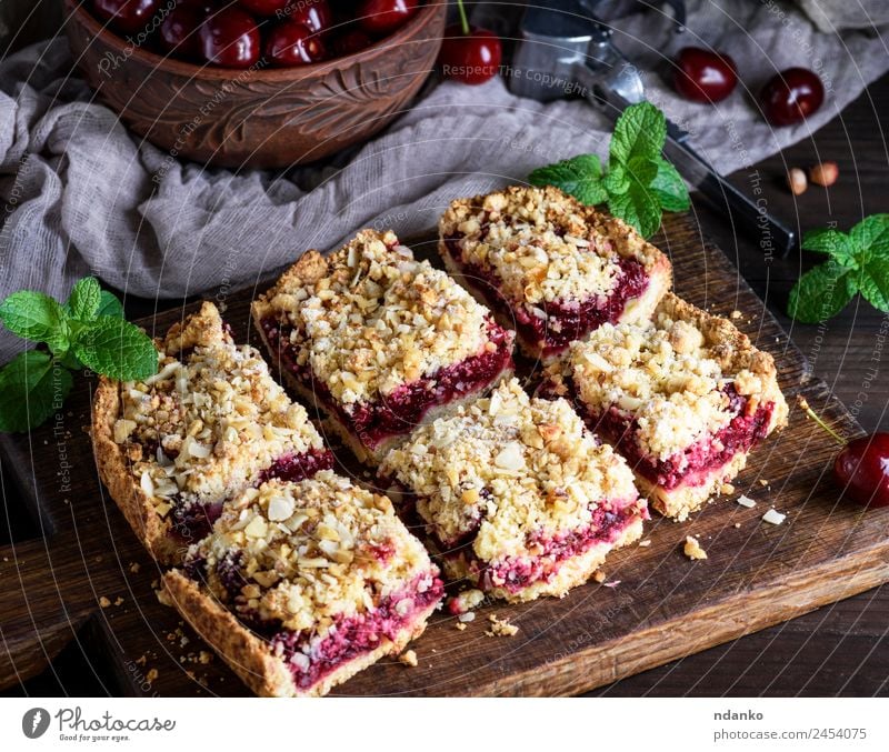 quadratische Kuchenstücke zerbröckeln Frucht Dessert Süßwaren Vegetarische Ernährung Tisch Holz frisch lecker oben braun gelb gold grün rot schwarz Kirsche