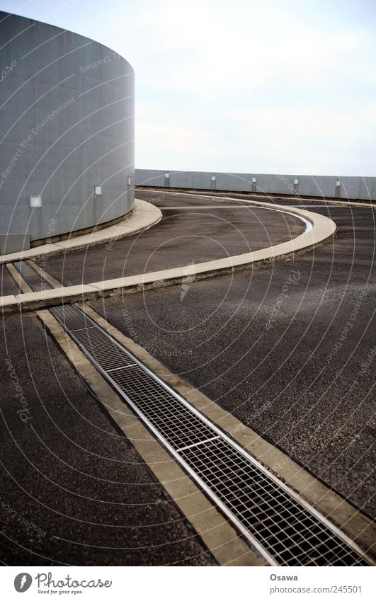 Parkhaus Rampe Kurve Steigung Neigung Berghang Gebäude Architektur Straße Teer Asphalt Beton Himmel Menschenleer Textfreiraum grau