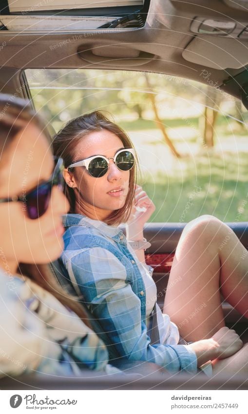 Zwei junge Frauen, die im Auto sitzen und sich ausruhen. Lifestyle Freude Glück schön Erholung Freizeit & Hobby Ferien & Urlaub & Reisen Ausflug Sommer Sonne