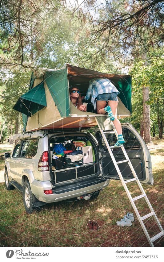 Frau geht die Leiter hinauf, um über dem Auto zu zelten. Lifestyle Freude Glück Freizeit & Hobby Ferien & Urlaub & Reisen Ausflug Camping Sommer wandern