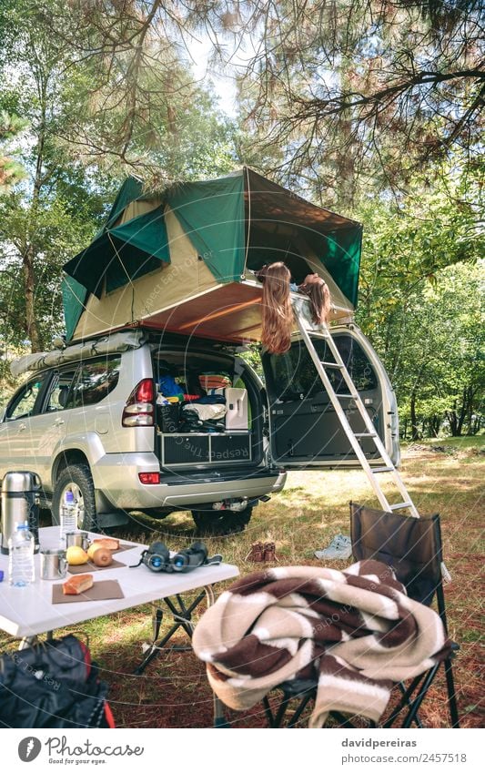 Frauen, die im Zelt über dem Auto liegen und die Natur betrachten. Lifestyle Freude Glück Erholung Freizeit & Hobby Ferien & Urlaub & Reisen Ausflug Abenteuer